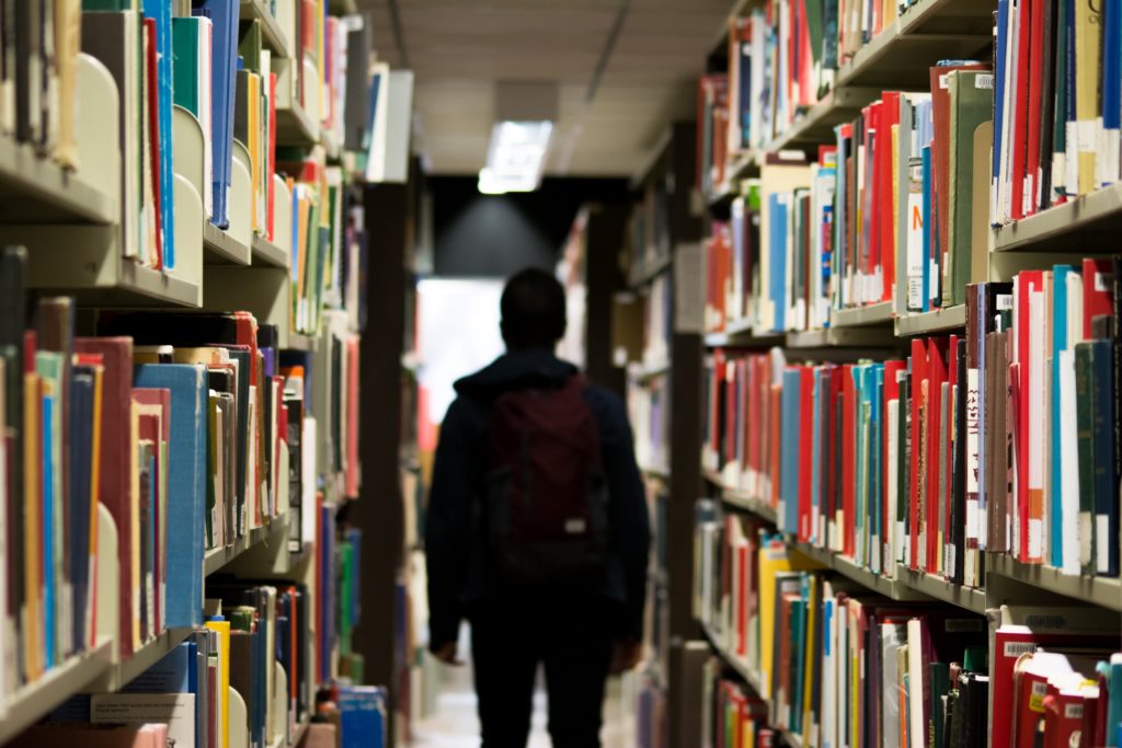 Student walking learning in a Library looking for HISTORY!